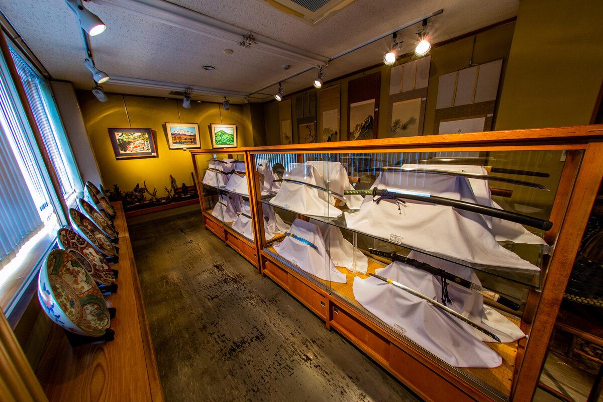 店内のショーケースに並ぶ日本刀と陶磁器