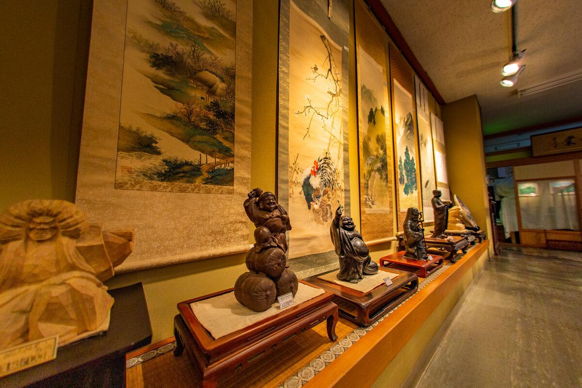 掛軸や木彫が並ぶ店内の展示棚